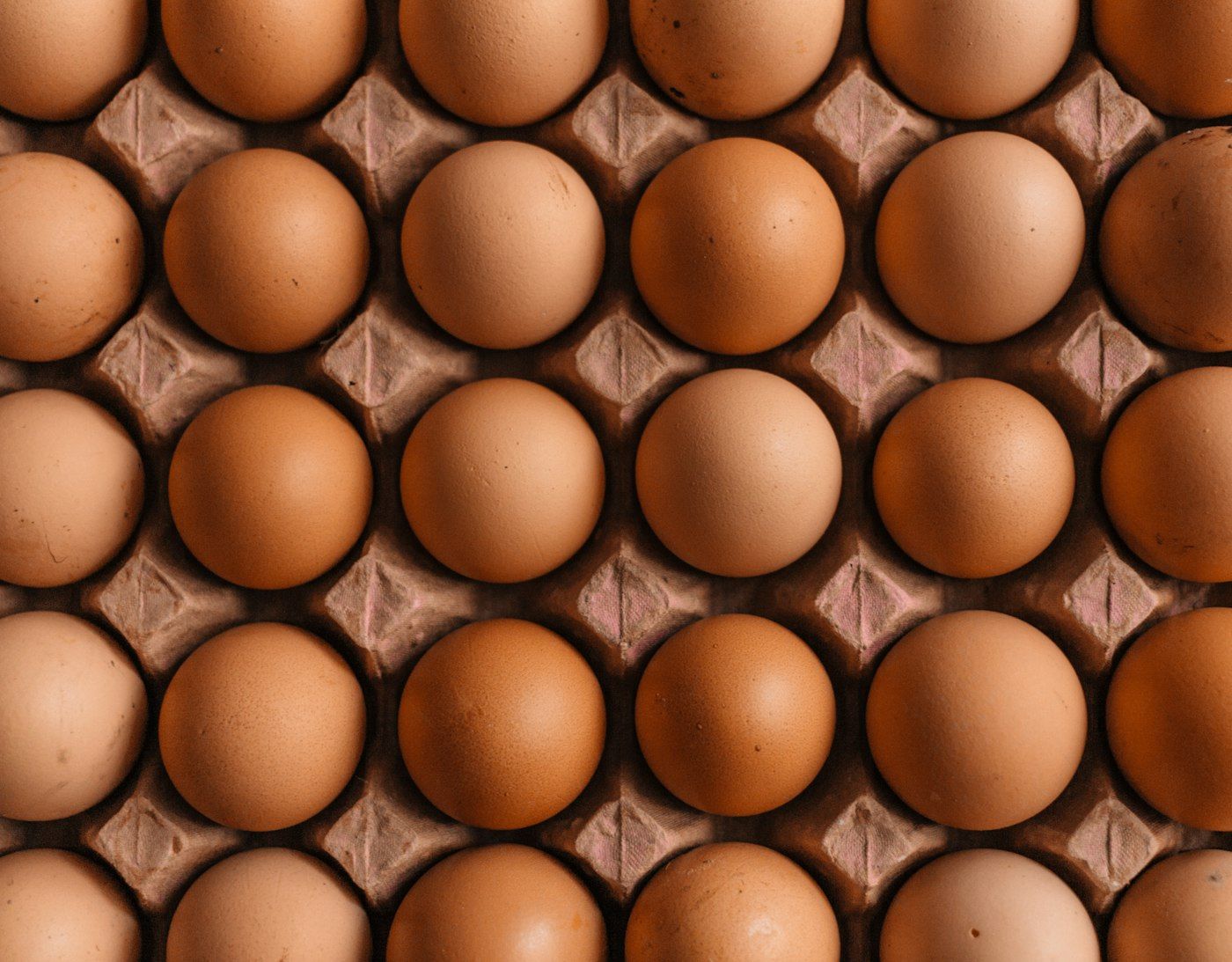 A tray of brown farm eggs photographed from directly above