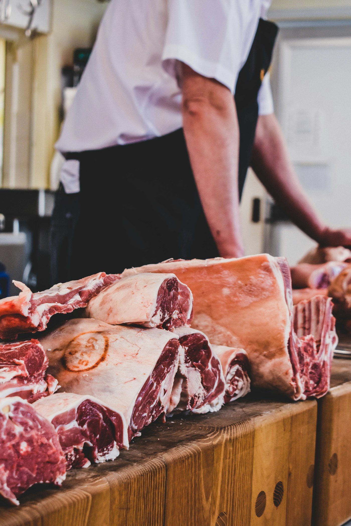 Fresh cuts of red meat arranged on a butcher’s wooden counter