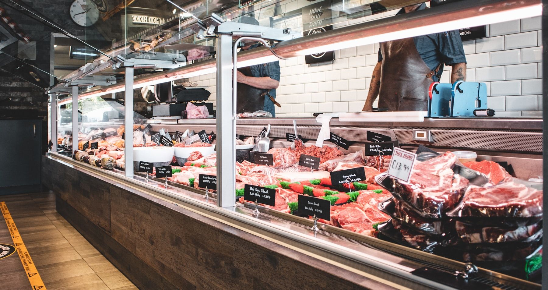 A clean, well-lit meat shop display counter stocked with fresh cuts